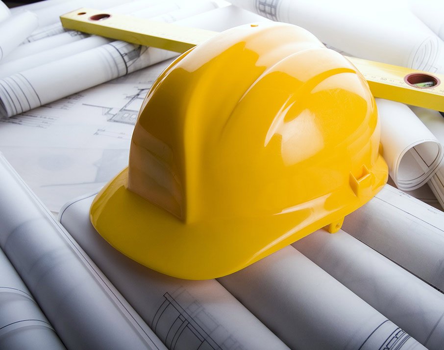 Yellow safety helmet on engineering blueprints — HA Linker project planning